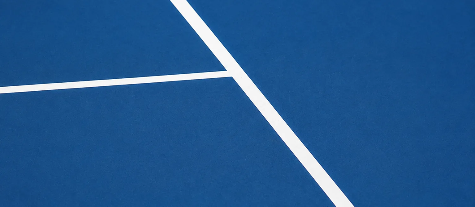 Service line and centre line markings on a blue hard tennis court