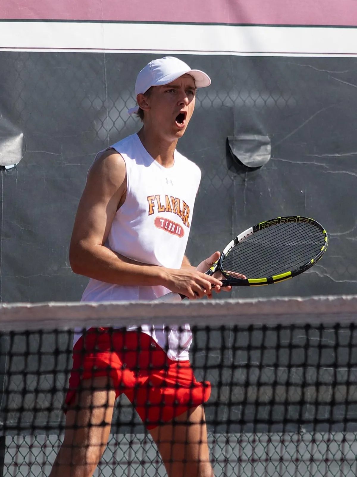 College tennis player celebrating a point in match kit