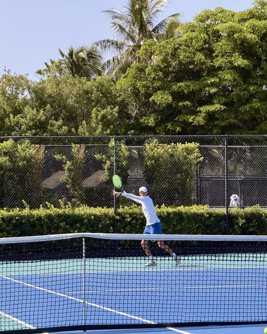 Coach stretching into a forehand volley at the net