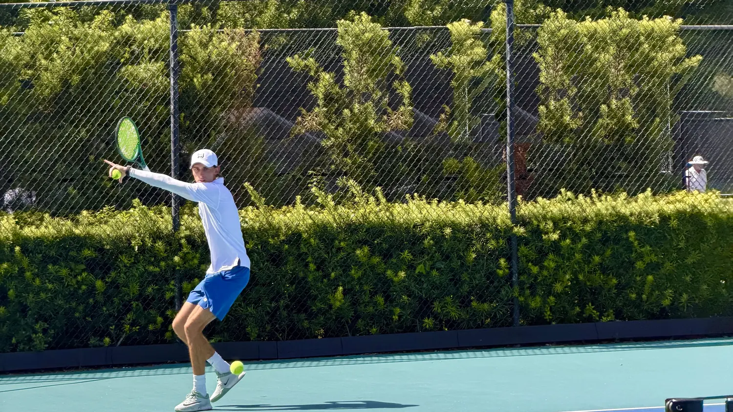 Coach Tom stretching into a forehand on a hard court