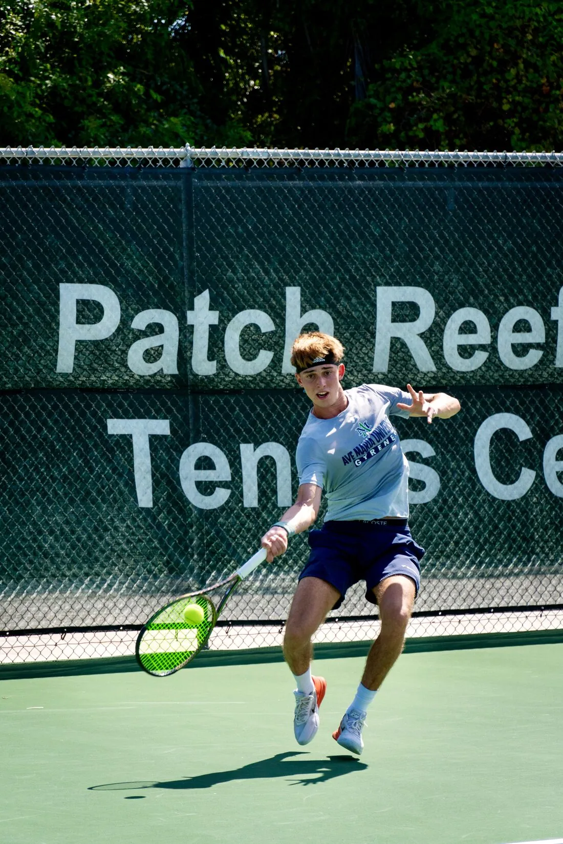 Coach Tom hitting a forehand on a hard court