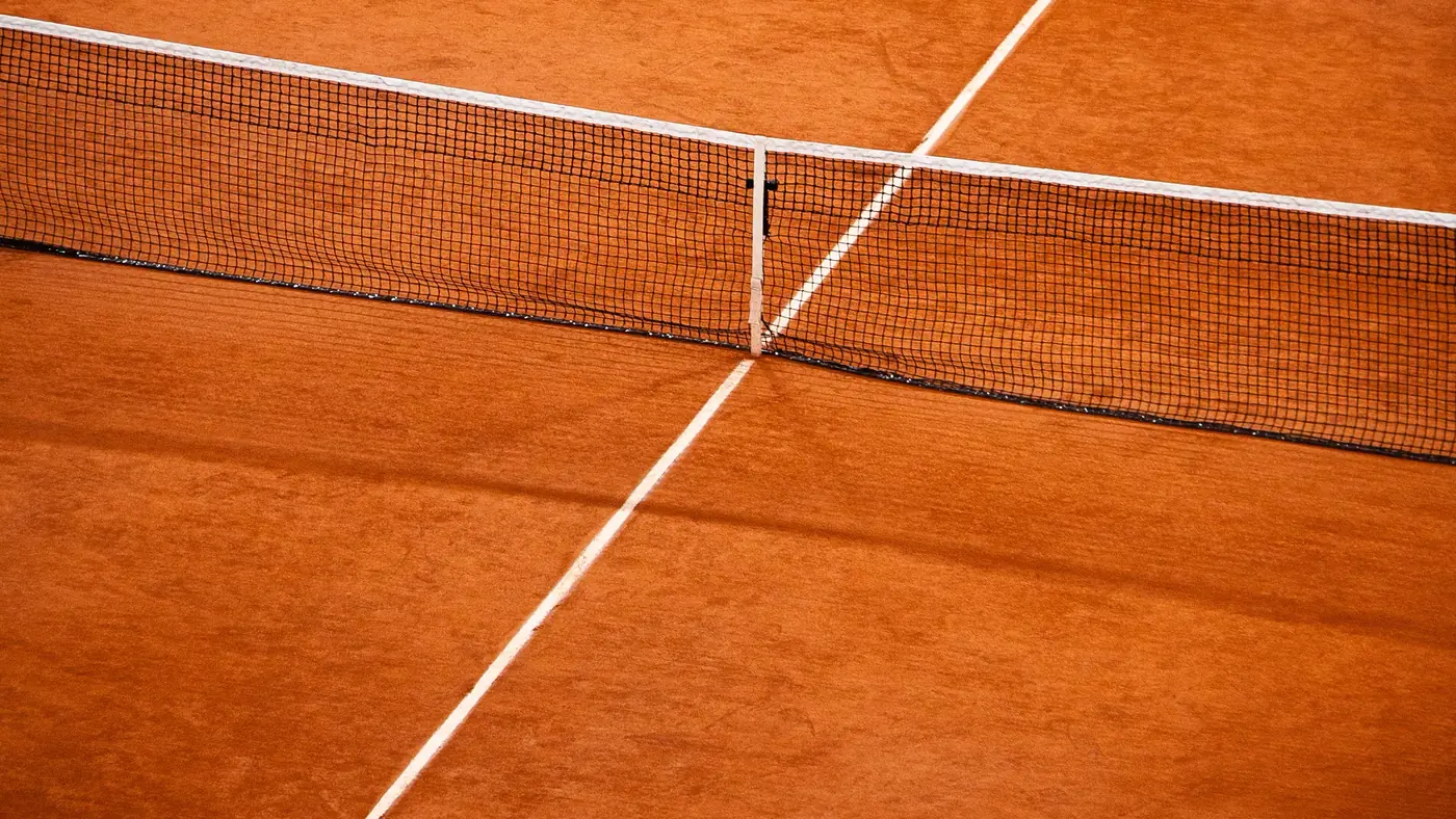 The net and centre service line on a clay tennis court, seen from above